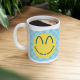 Ceramic mug on a table with smiley face design and personalised text.