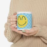 Person holding the ceramic mug with a smiley face and personalised text.